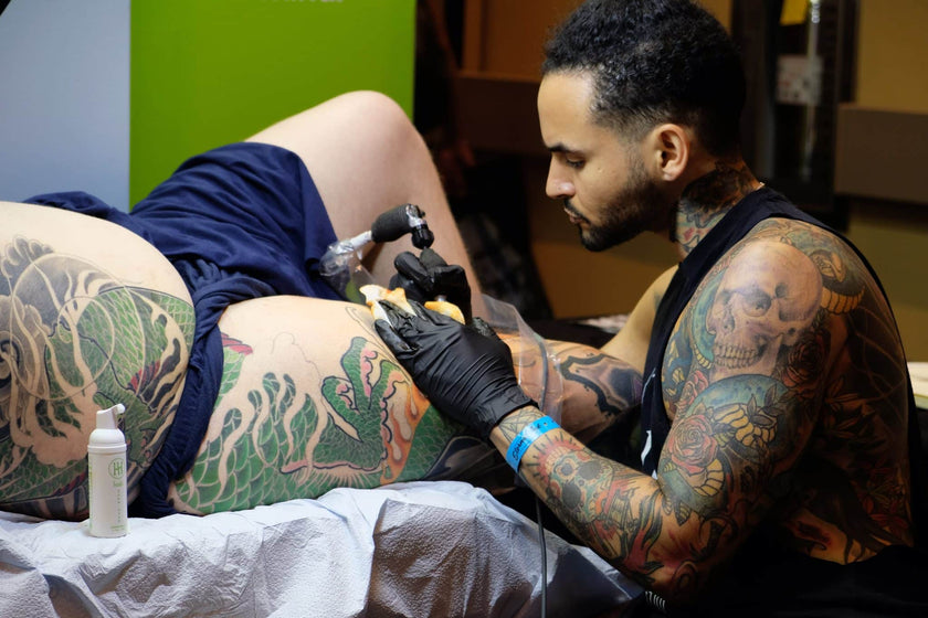 Jon Mesa working on leg sleeve at Empire Tattoo Convention